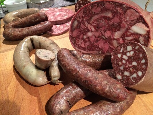 Verschiedene Würste und Presssack auf einem Holzbrett